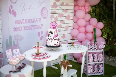 Montaje completo de cumpleaños con backdrop rosado y arco de globos