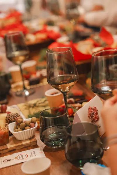 Mesa larga con copas de vino y tablas de quesos y charcutería