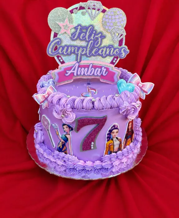 Bizcocho de cumpleaños en tonos lila con topper de princesas y el número siete