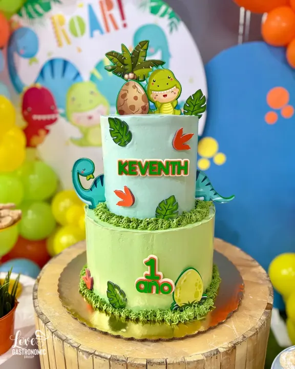 Bizcocho de dos pisos con tema de dinosaurios para un primer cumpleaños
