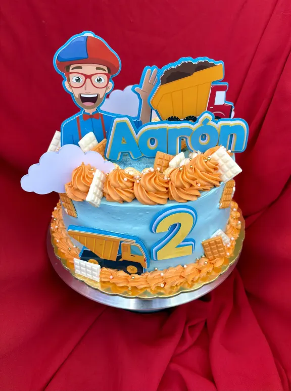 Bizcocho azul y naranja con topper de camión para un segundo cumpleaños