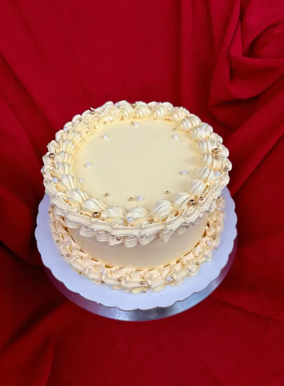 Bizcocho de dos pisos en crema natural con borde de merengue