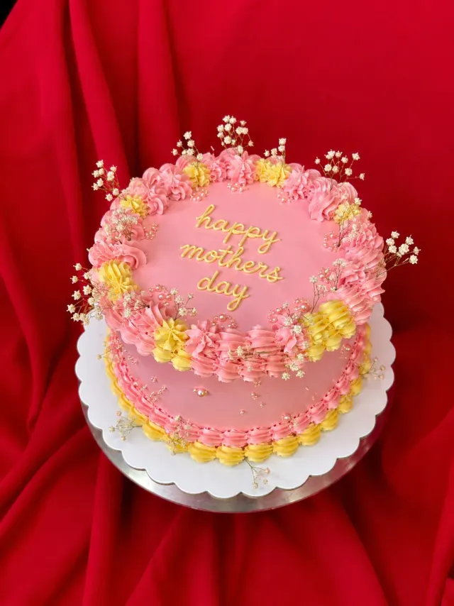 Bizcocho rosado del Día de las Madres con flores de buttercream en tonos pastel