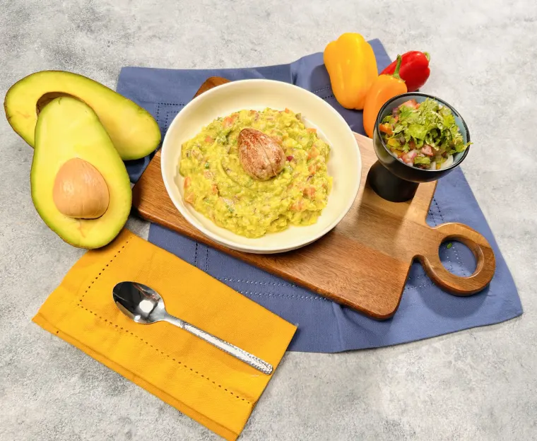 Fotografía de producto: bowl de guacamole con aguacate y vegetales sobre tabla de madera