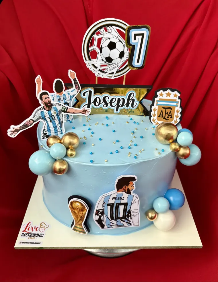 Bizcocho celeste con tema de fútbol y globos para un séptimo cumpleaños